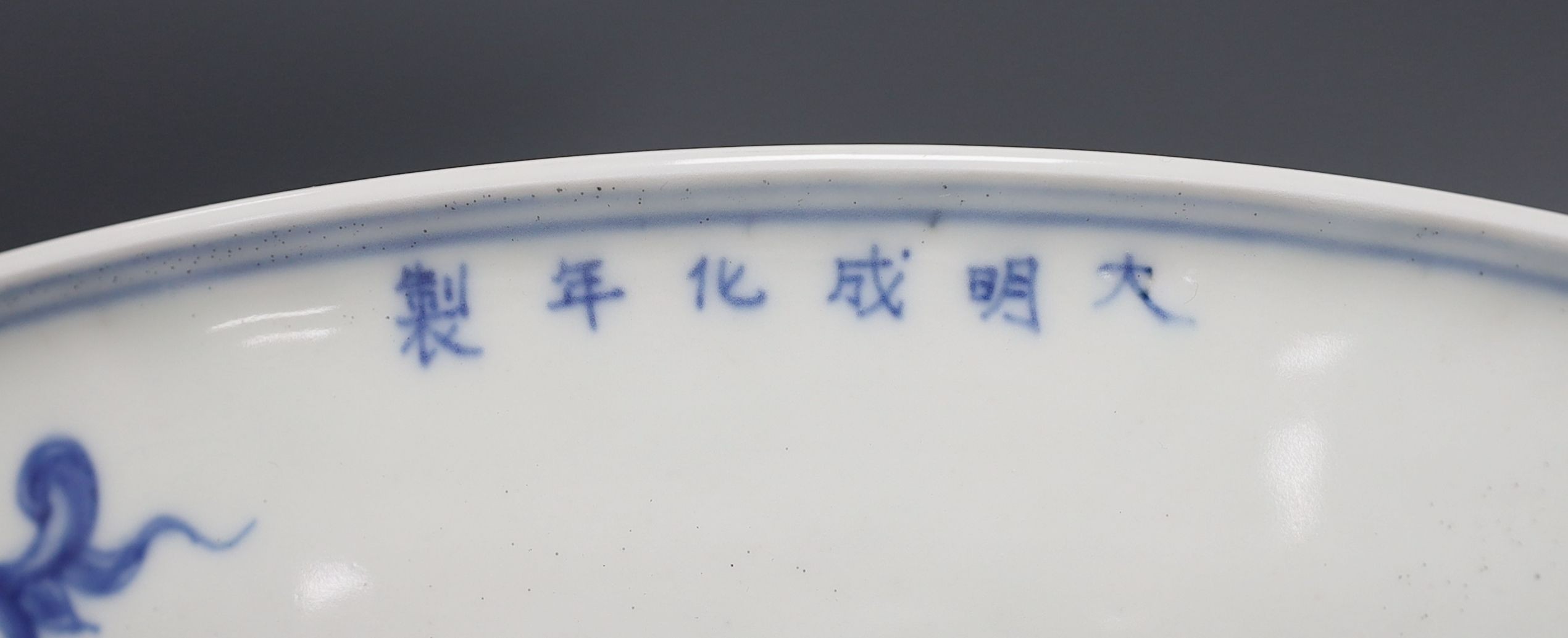A 19th century Chinese blue and white celadon ground charger, marked to base, together with another blue and white Chinese charger (2)
